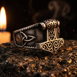 Bague Mjolnir Triquetra ERYTH — ambiance pierre volcanique et lumiere de bougie