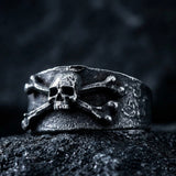 Bague Crane et Os ERYTH — eclairage dramatique froid sur pierre volcanique